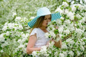 白い花の香りをかぐ少女