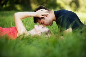 芝生でキスするカップル