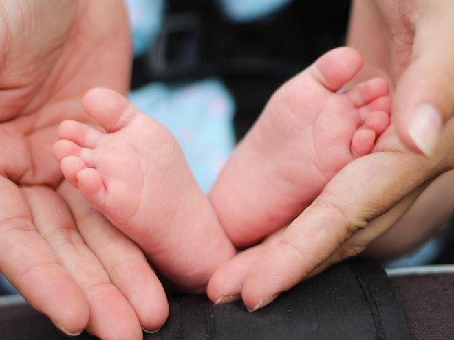 赤ちゃんの足と、それを支える女性の手